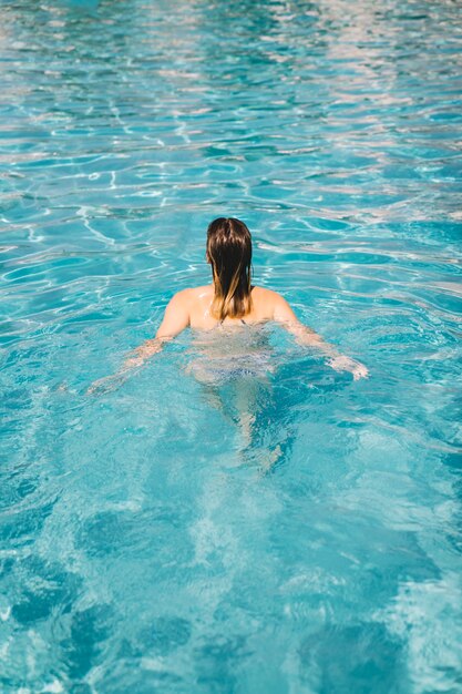 Vista trasera de mujer en piscina