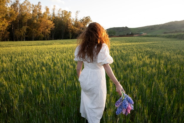 Vista trasera mujer con ramo de flores