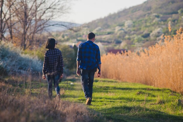 Vista trasera de pareja caminando por el bosque