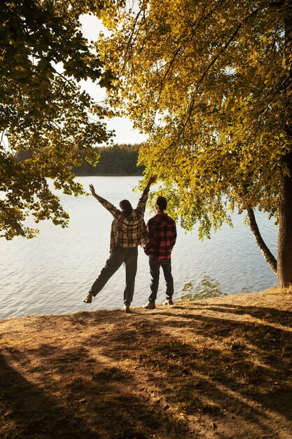 Vista trasera pareja feliz en la naturaleza