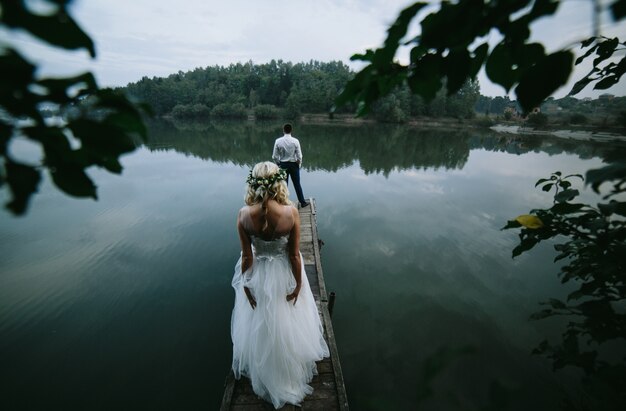 Vista trasera de recién casados en una plataforma de madera