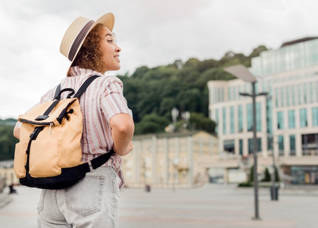 Vista trasera rizado mujer viajando sola