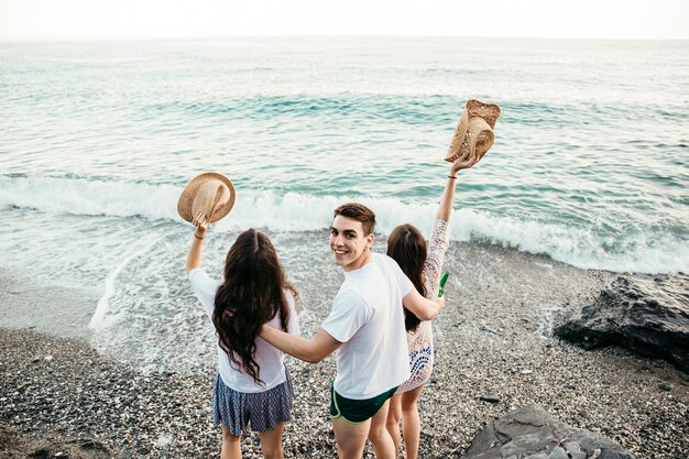 Vista trasera de tres amigos en la playa