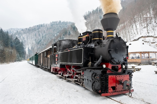 Vista del tren de vapor de liquidación Mocanita en una estación de tren en la nieve del invierno Rumania