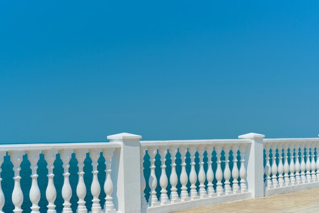 Vista de verano con balaustrada blanca clásica y terraza vacía con vistas al mar Mediterráneo idea de vacaciones Espacio libre para texto