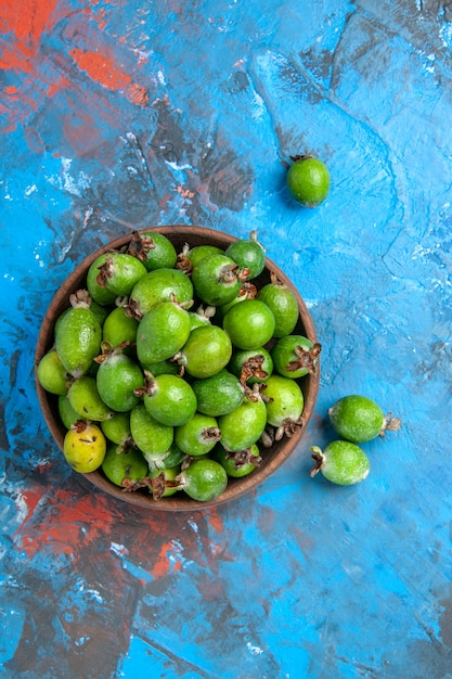 Foto gratuita vista vertical de deliciosas feijoas frescas de bomba de vitamina en una olla marrón