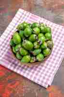 Foto gratuita vista vertical de feijoas verdes naturales frescas en una pequeña olla marrón