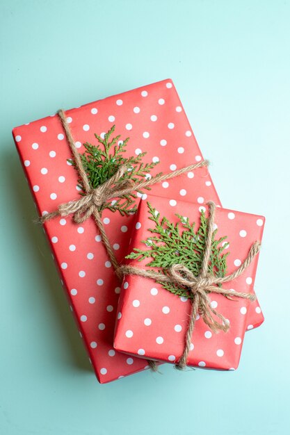 Vista vertical del fondo de Navidad con cajas de regalo sobre fondo verde pastel