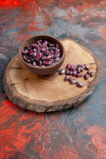Foto gratuita vista vertical de instant pot black beansin un recipiente marrón sobre una bandeja de madera sobre fondo de colores mezclados