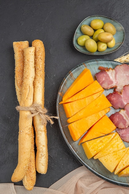 Foto gratuita vista vertical de los mejores deliciosos bocadillos para vino sobre una toalla sobre un fondo oscuro