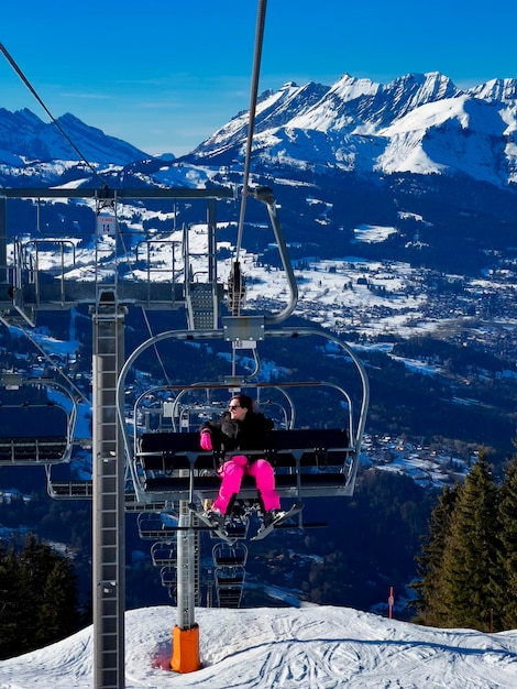 Vista vertical de la mujer en el telesilla en los alpes franceses, Europa