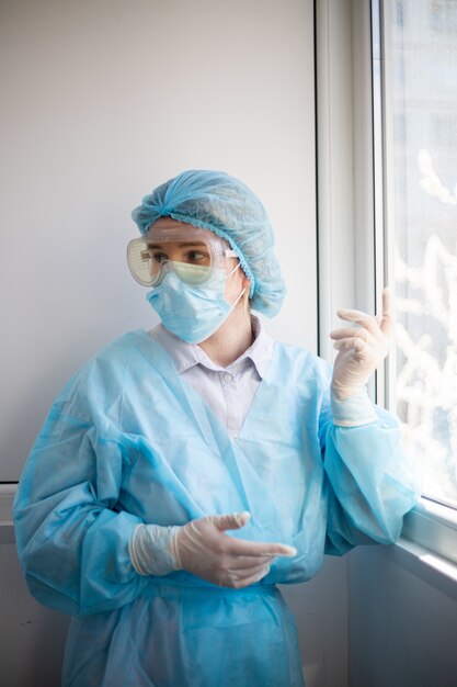 Vista vertical de una mujer vistiendo un equipo de protección de personal médico