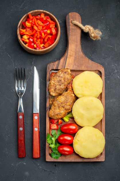 Vista vertical de sabrosas chuletas de verduras picadas para cenar en la oscuridad