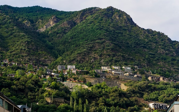 Vistas de edificios en una montaña verde con un cielo sombrío