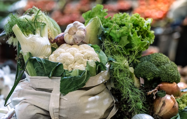 Visualización de brócoli orgánico maduro fresco, ensalada con verduras y verduras en una bolsa de algodón en el mercado de agricultores de fin de semana