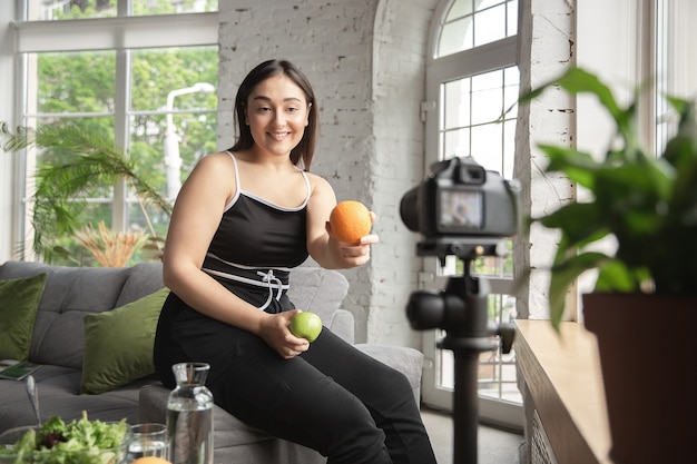 Vitaminas. Bloguera caucásica, mujer hace vlog cómo hacer dieta y perder peso