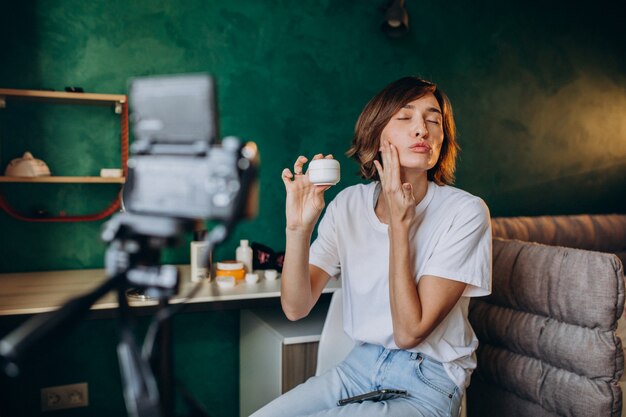 Vlogger de belleza de mujer filmando vlog sobre cremas