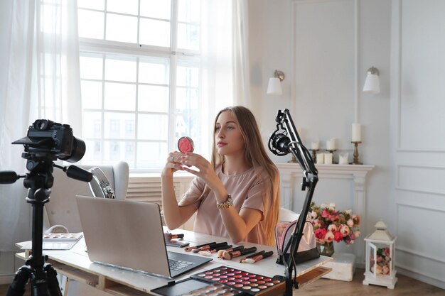 Vlogger de belleza. Mujer joven grabando un tutorial de maquillaje