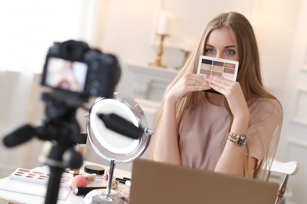 Vlogger de belleza. Mujer joven grabando un tutorial de maquillaje