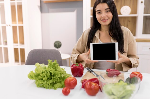 Vlogger femenina en casa grabando video con tableta