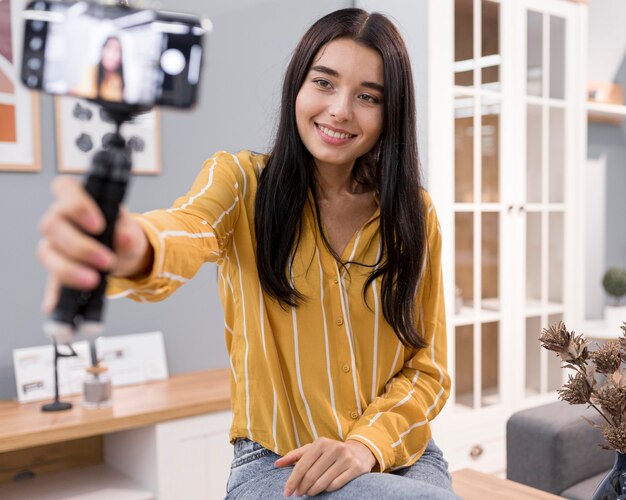 Vlogger femenina en casa con smartphone