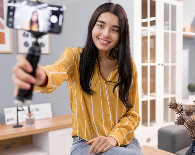 Vlogger femenina en casa con smartphone