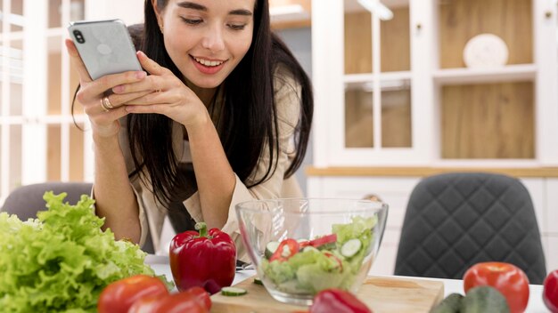 Vlogger femenina en casa tomando fotografías con smartphone