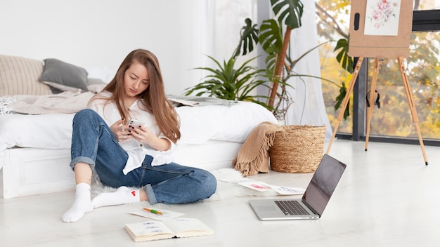 Foto gratuita vlogger femenina comprobando su teléfono