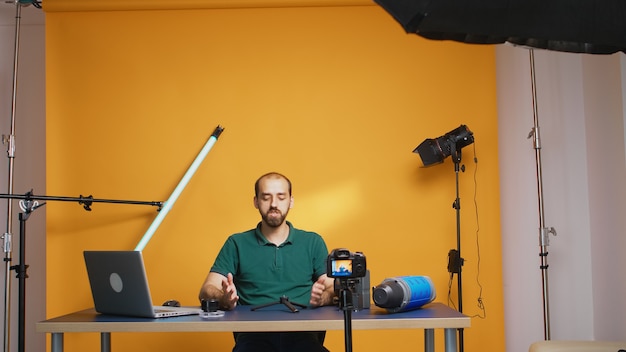 Foto gratuita vlogger graba testimonio sobre mini trepied para suscriptores. tecnología profesional de equipos de video y fotografía de estudio para el trabajo, estrella de las redes sociales de estudio fotográfico e influencer