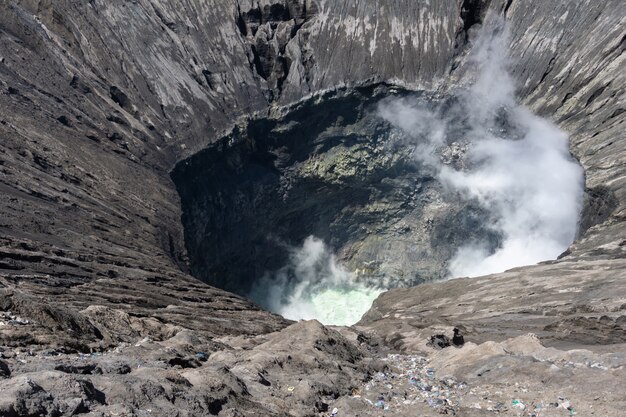 Volcán cráter expulsando humo