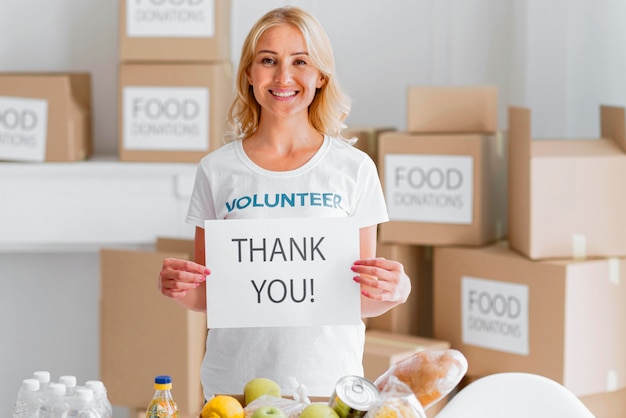 Voluntaria sonriente agradeciéndole por donar comida