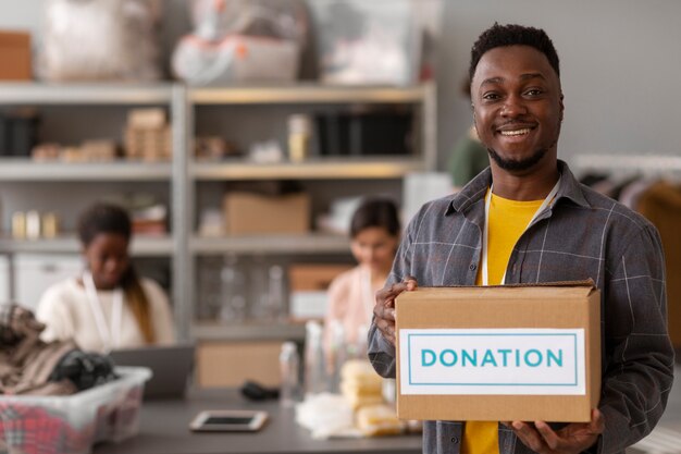 Voluntariado ayudando con caja de donación.