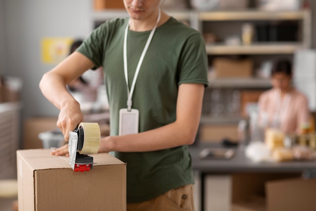 Voluntariado ayudando con caja de donación.