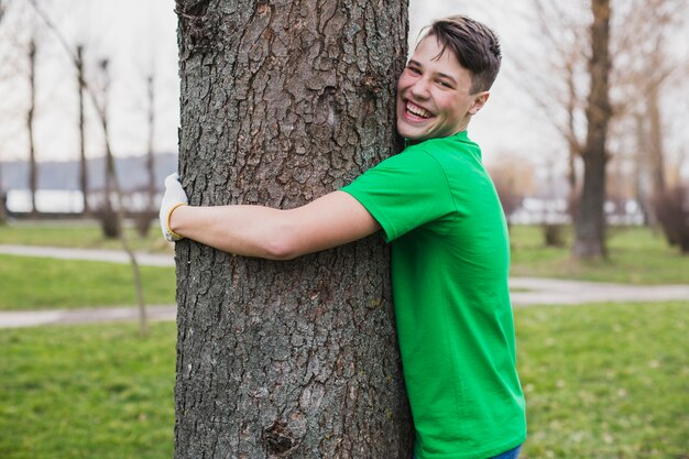 Voluntario abrazando árbol