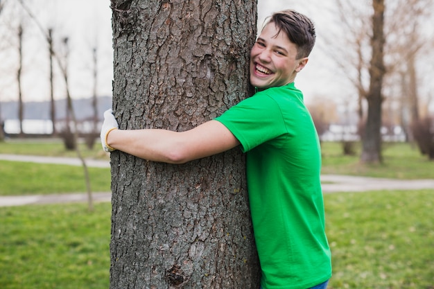 Voluntario abrazando árbol