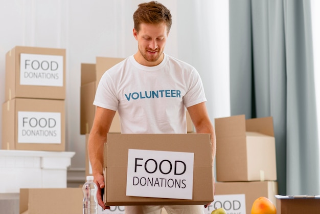 Voluntario masculino trabajando con cajas con donaciones