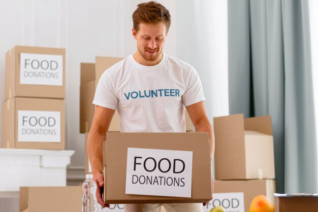 Voluntario masculino trabajando con cajas con donaciones