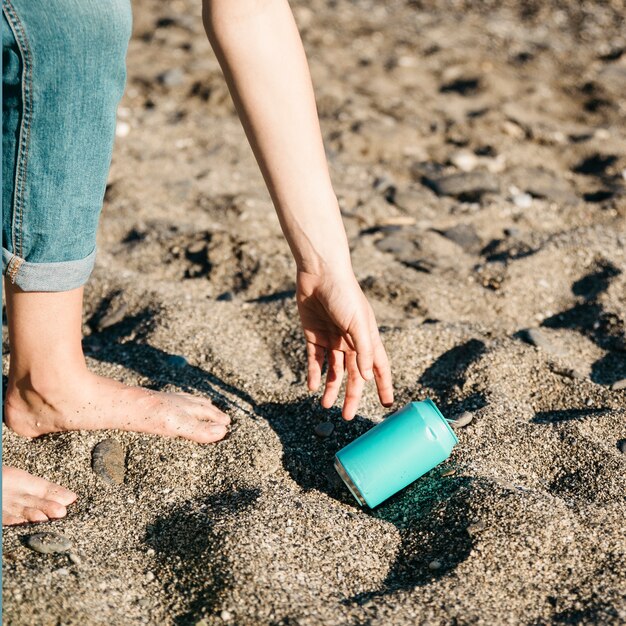 Voluntario recogiendo lata en la playa