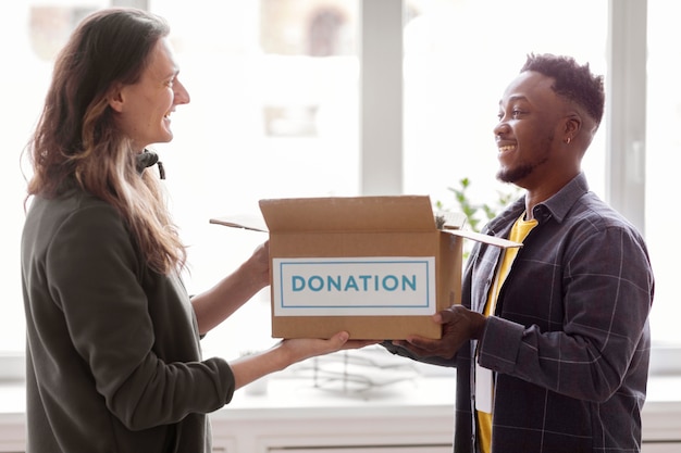 Foto gratuita voluntario recolectando una caja de donación de otro voluntario