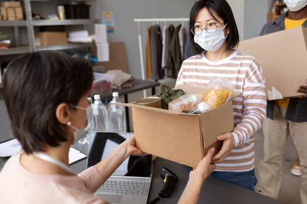 Voluntario recolectando una caja de donación de otro voluntario