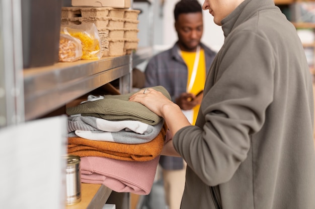 Voluntario seleccionando y organizando donaciones de ropa para organizaciones benéficas.