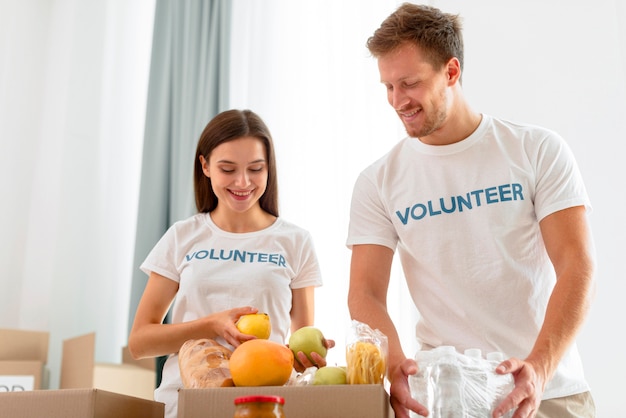 Foto gratuita voluntarios alegres preparando comida para donación