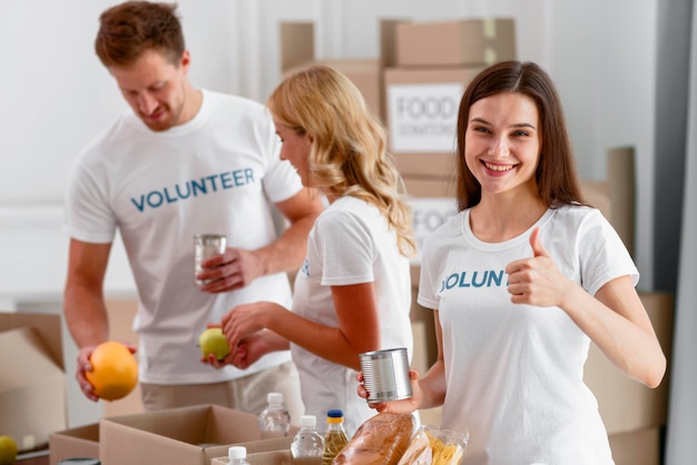 Foto gratuita voluntarios ayudando con donaciones de alimentos y dando el visto bueno