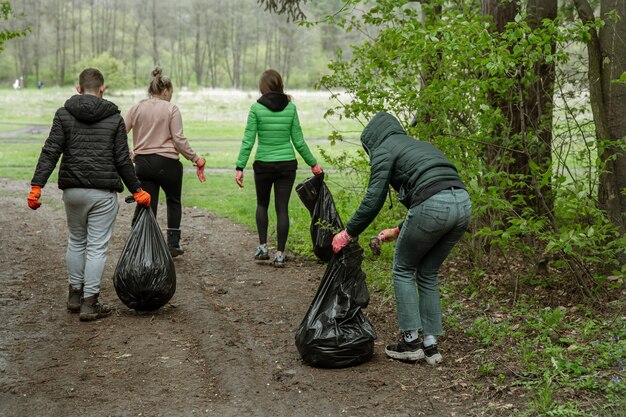 Voluntarios con bolsas de basura en un viaje a la naturaleza, limpian el medio ambiente.