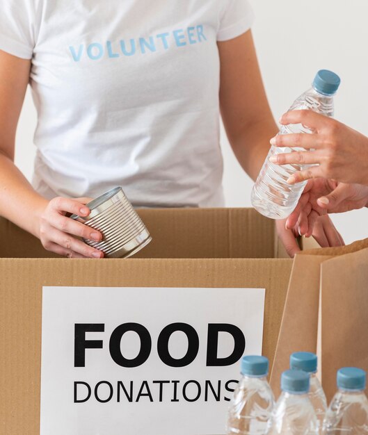 Voluntarios con caja y agua para donación