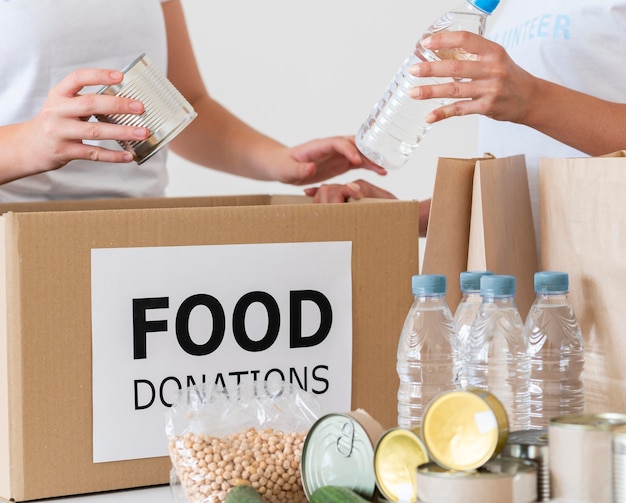 Voluntarios con caja y botellas de agua para donación.