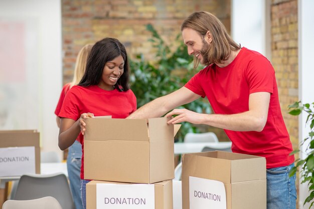 Voluntarios en camisetas rojas que participan en la distribución de donaciones.