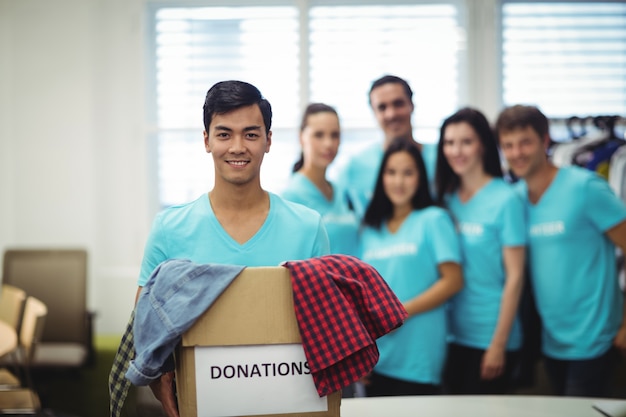 Voluntarios colgar la ropa en caja de donación