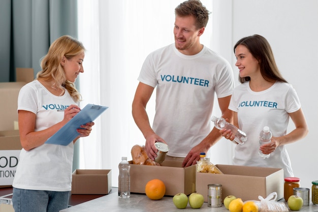 Voluntarios de donación de alimentos preparando cajas con provisiones