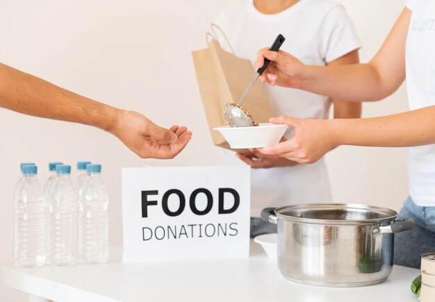 Voluntarios entregando comida de donación en un tazón